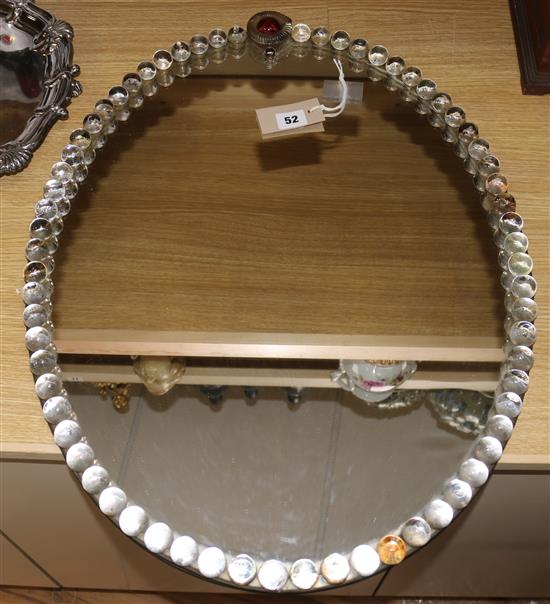 A Venetian oval wall mirror, with spherical glass bead border centred by a ruby glass cabochon